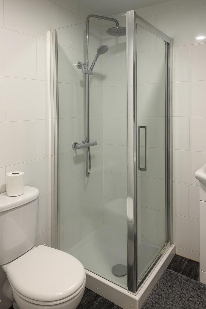 Modern tiled bathroom with a framed glass showe...