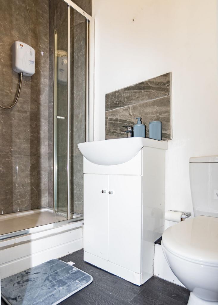 A modern bathroom featuring a shower enclosure,...