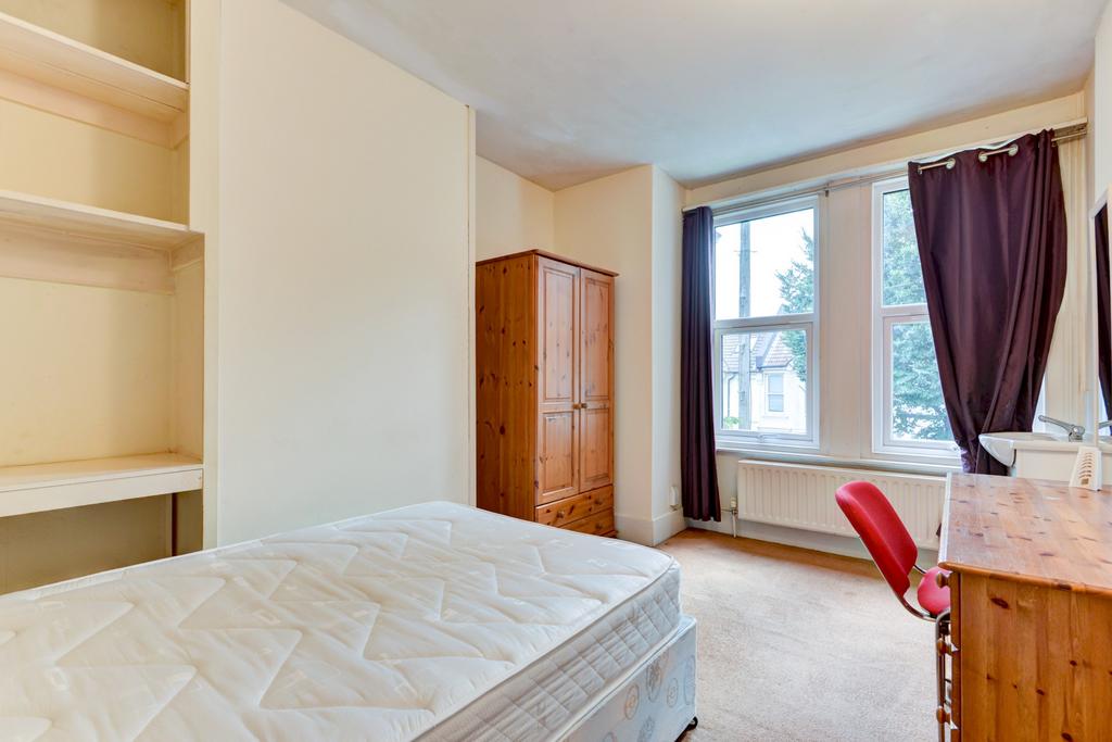 Bright, simply furnished bedroom with a large w...