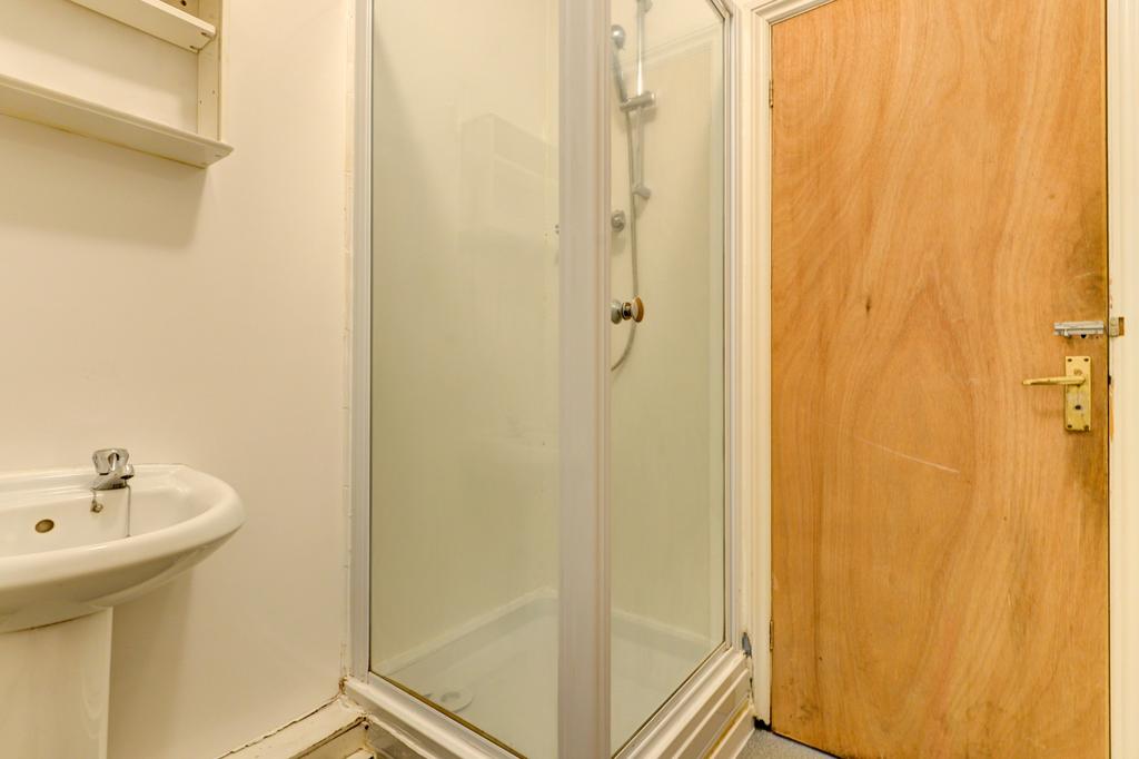 Compact, clean bathroom featuring a glass-enclo...