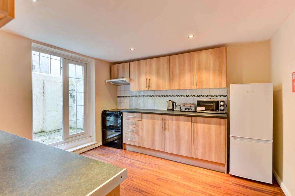A modern kitchen with light wooden cabinets, a ...