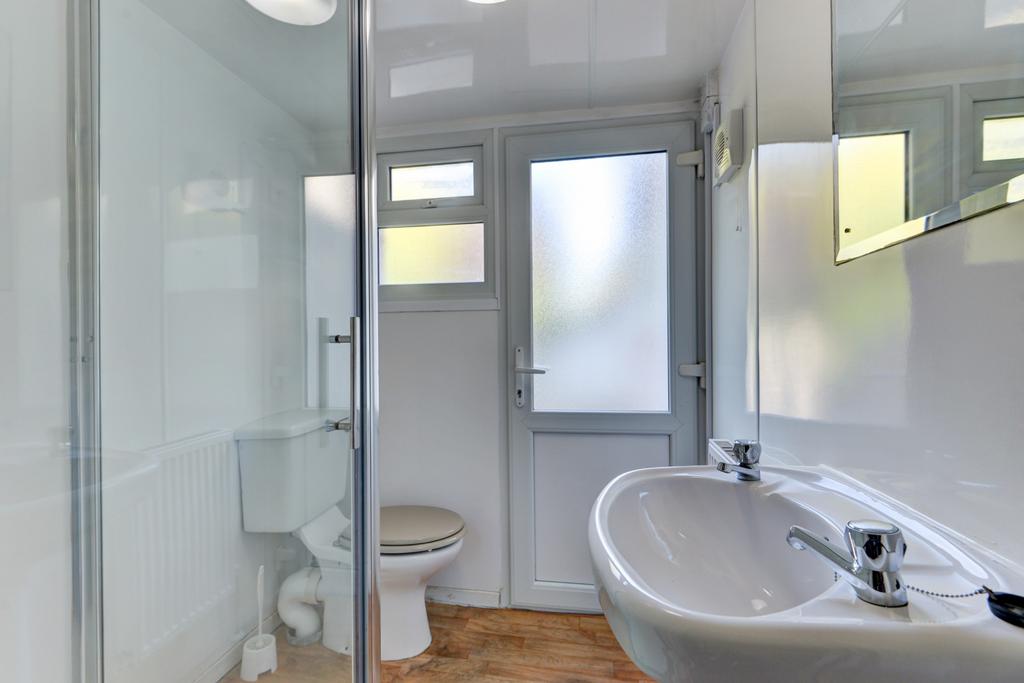 Bright, modern bathroom with a corner glass sho...