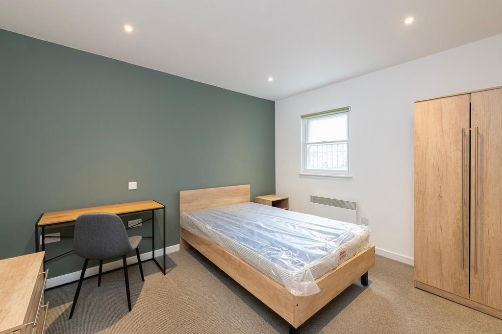 A spacious and modern double bedroom, featuring...
