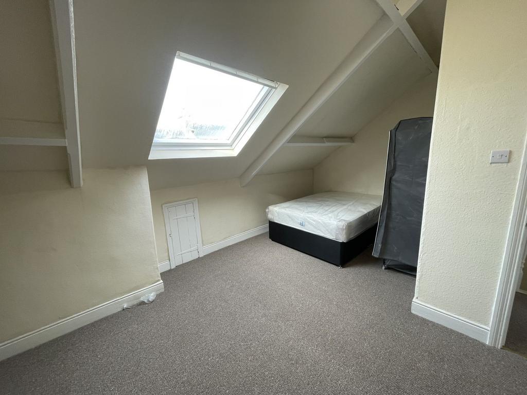 A bright, spacious bedroom with sloped ceiling ...