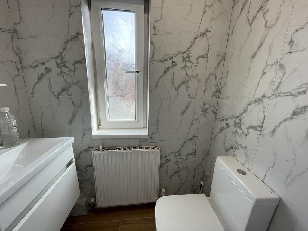 A modern bathroom featuring elegant white and g...