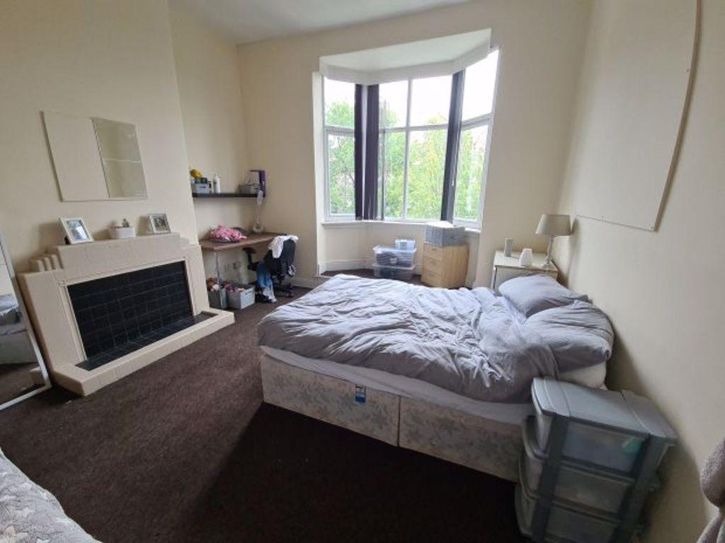 A spacious master bedroom featuring a large bay...