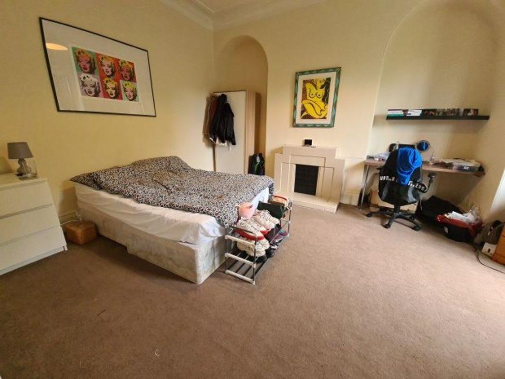 A spacious double bedroom featuring a comfortab...
