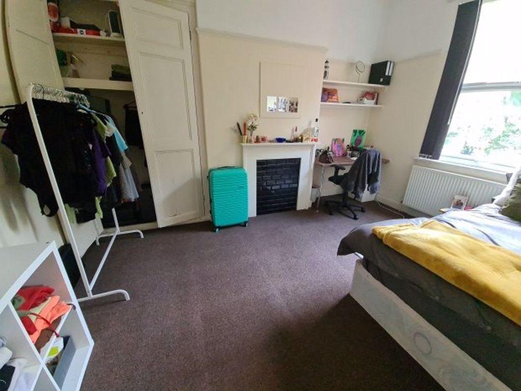 A spacious and well-lit bedroom featuring a lar...