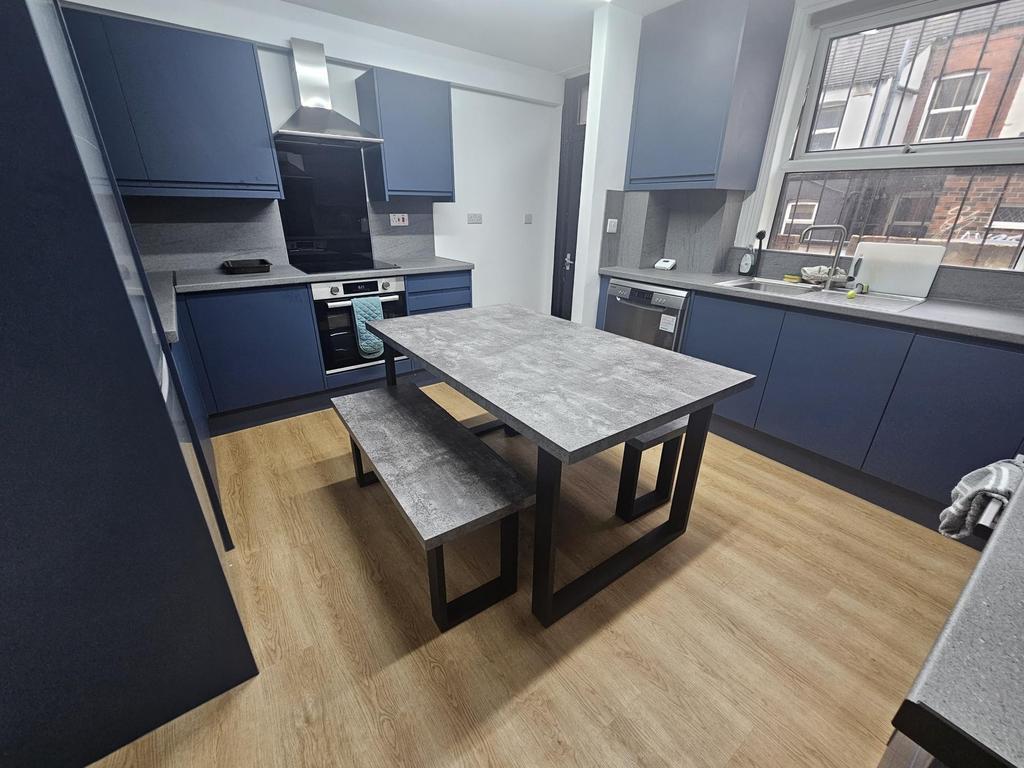 A modern kitchen with ample blue cabinetry, a r...