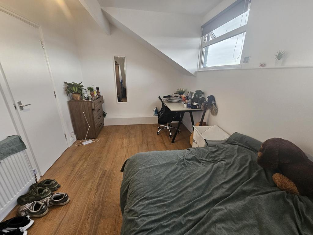 A cozy bedroom with a neatly made bed, natural ...