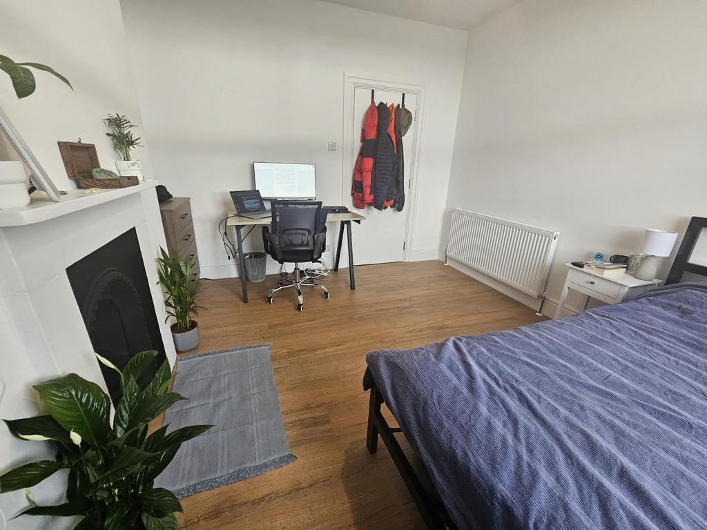 A bright and tidy bedroom featuring a comfortab...