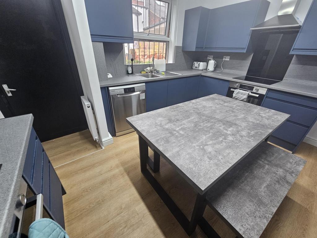 A modern kitchen with blue cabinetry and a larg...