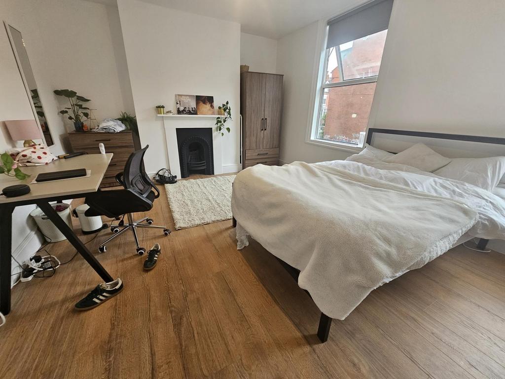 A well-maintained bedroom featuring a large bed...