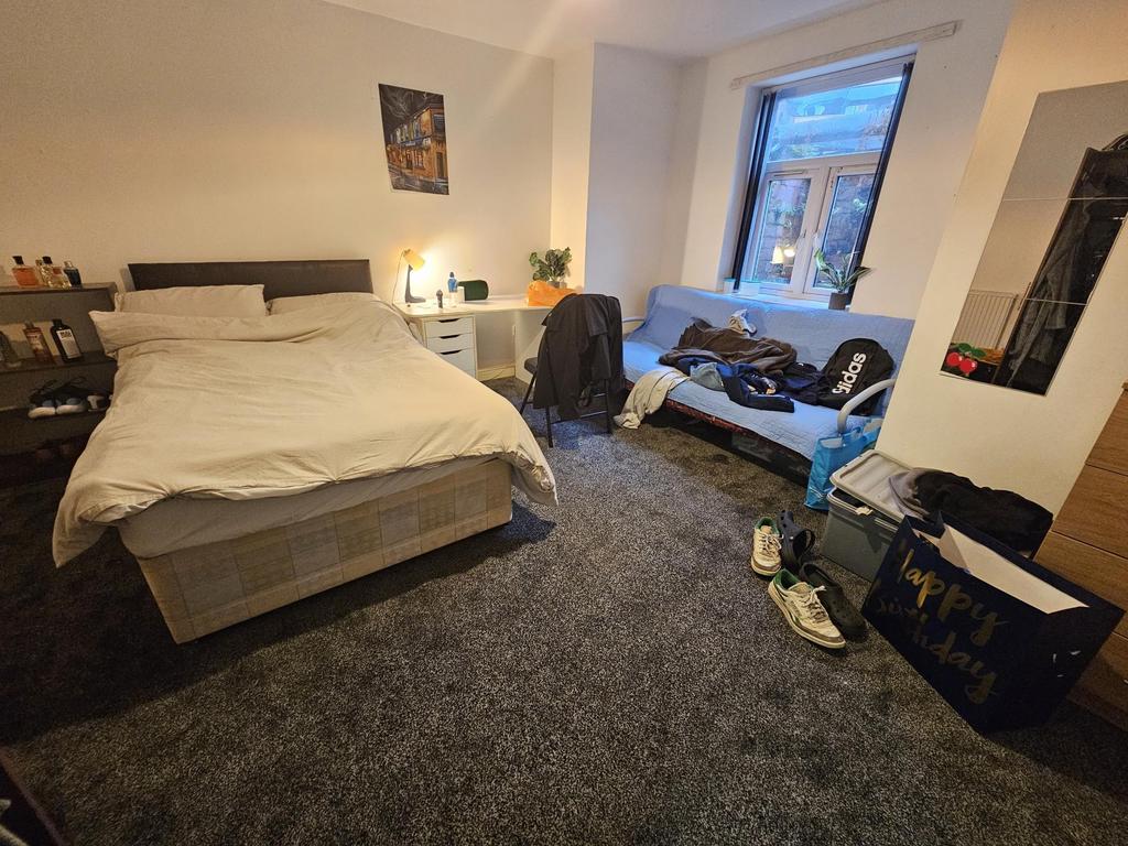 A spacious and well-lit bedroom with a comforta...