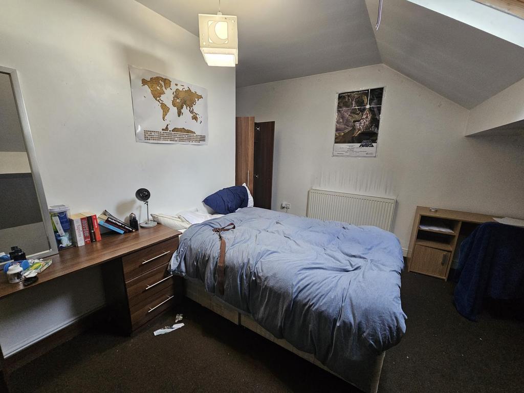 A cozy student bedroom featuring a neatly made ...