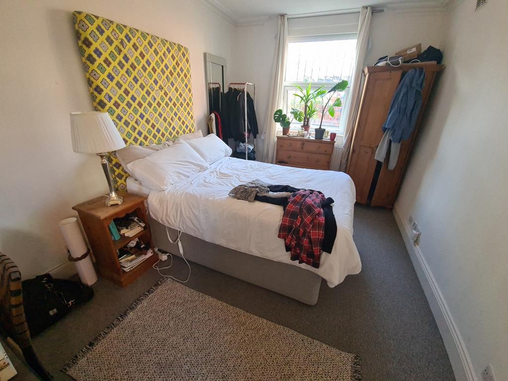 A cozy bedroom featuring a double bed with cris...