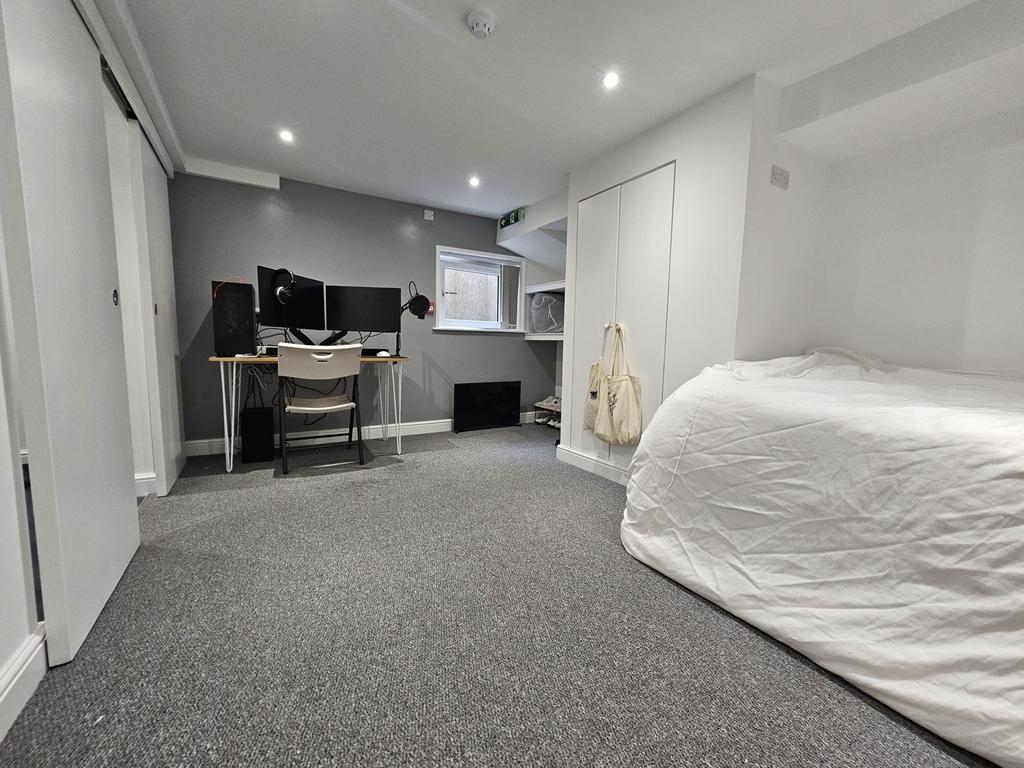 A tidy and well-lit bedroom featuring a large b...