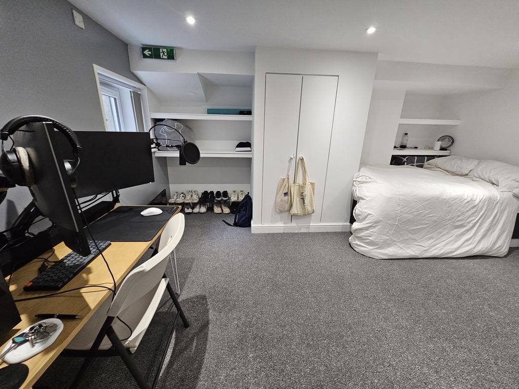A bright and clean bedroom featuring a comforta...
