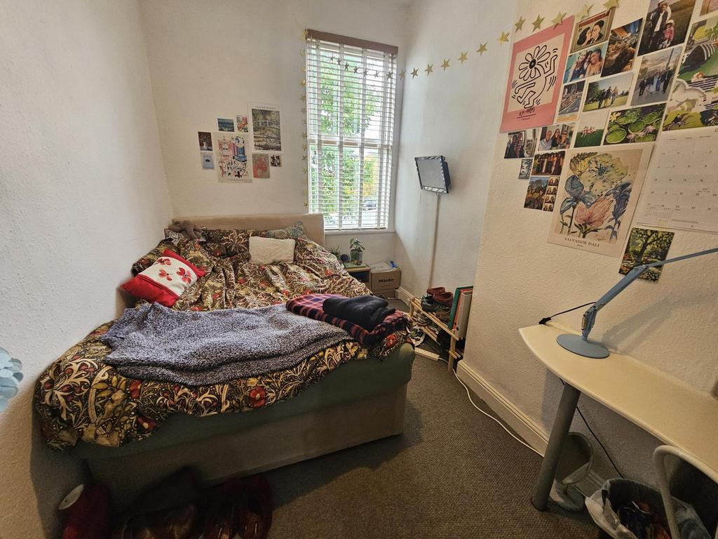 A cozy bedroom featuring a bed with colorful be...