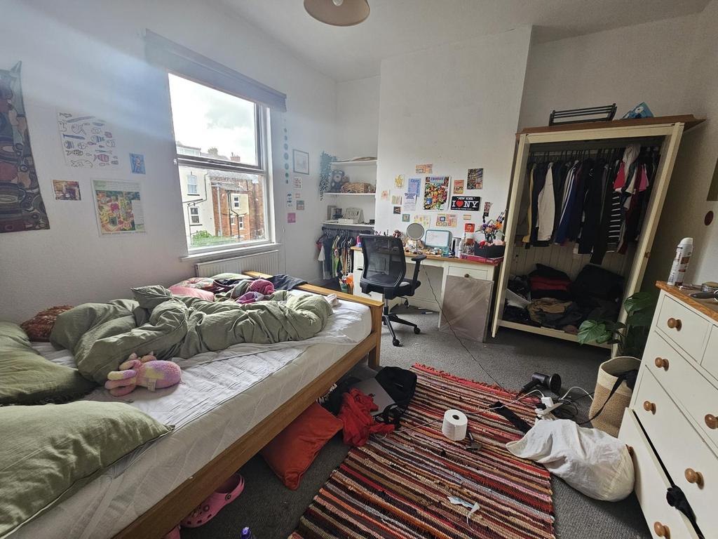 A cozy bedroom filled with personal belongings,...