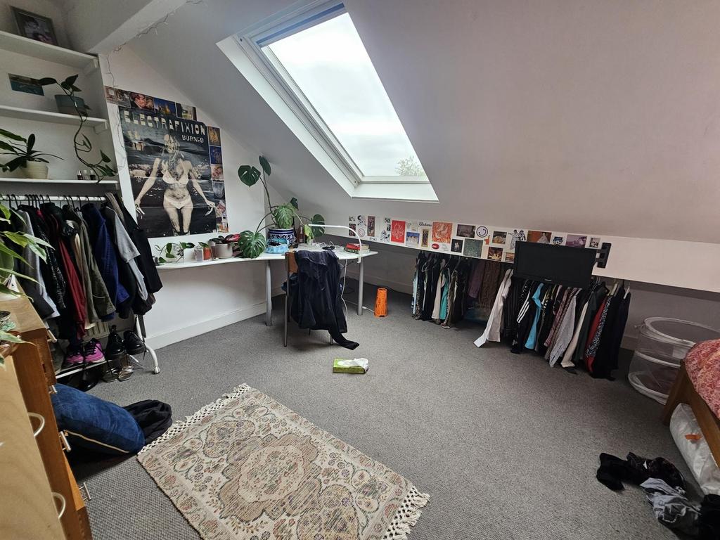 A bright and cozy bedroom with a skylight windo...
