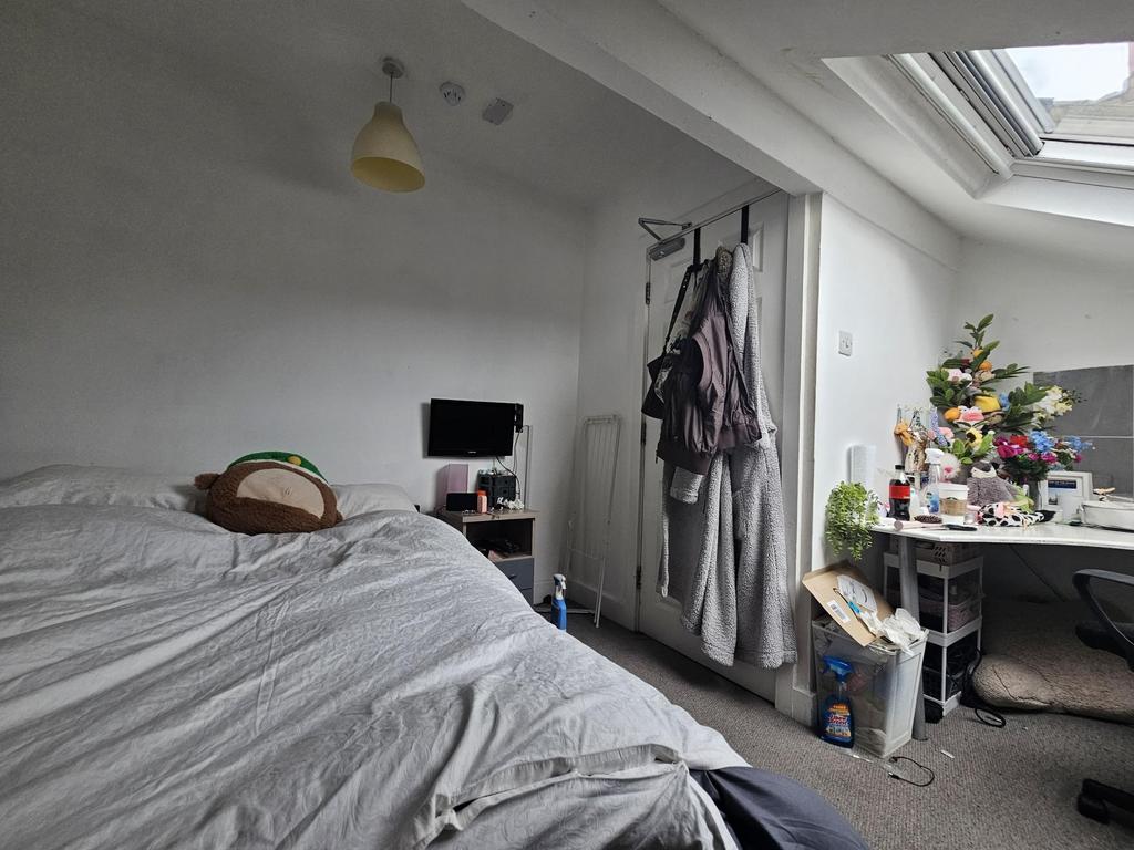 A cozy bedroom with a large bed, illuminated by...
