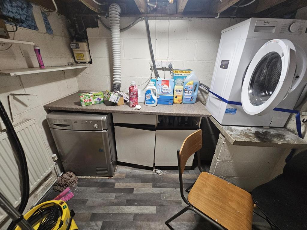 A compact kitchen area featuring a washing mach...
