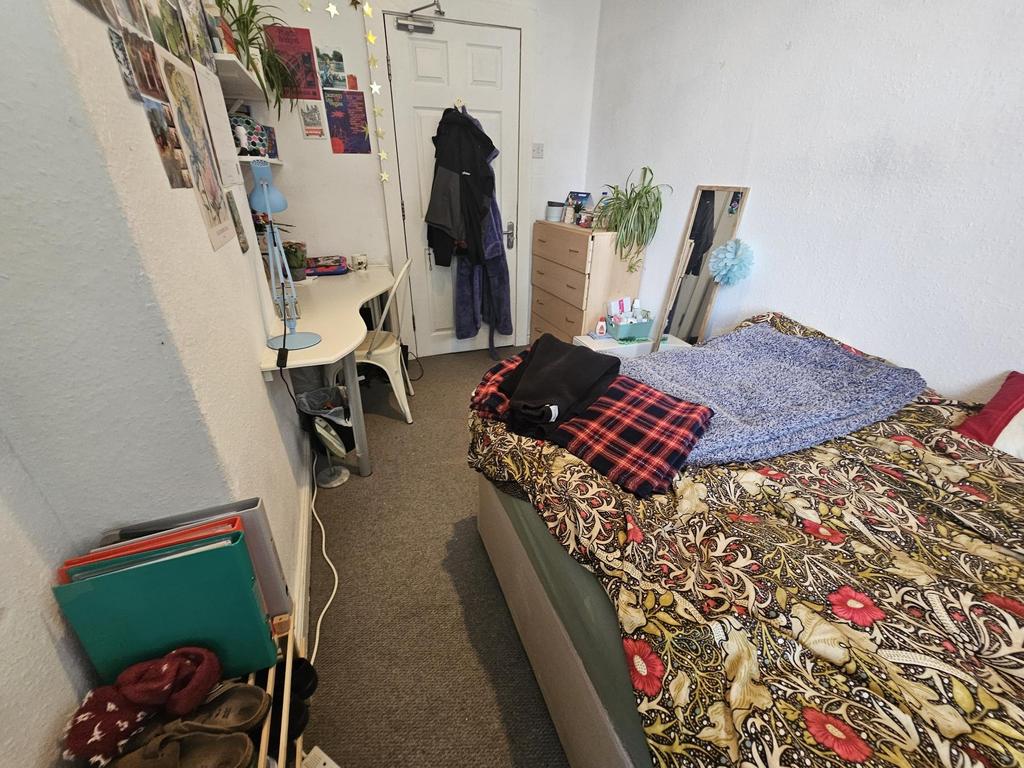 A cozy bedroom with a bed covered in a floral d...