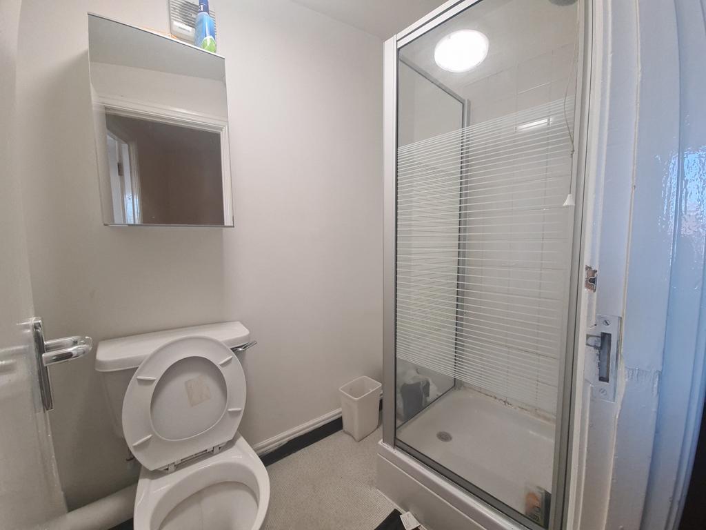 A clean, modern bathroom with a glass-enclosed ...