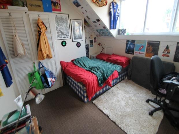 A comfortable student bedroom featuring a doubl...