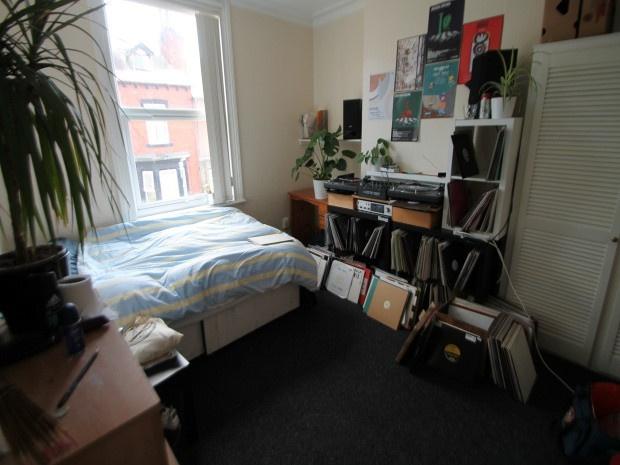A cozy living space featuring a bed, desk area,...