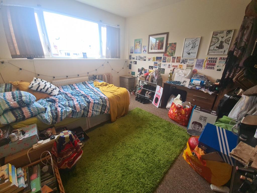 Cozy bedroom featuring a single bed with colorf...