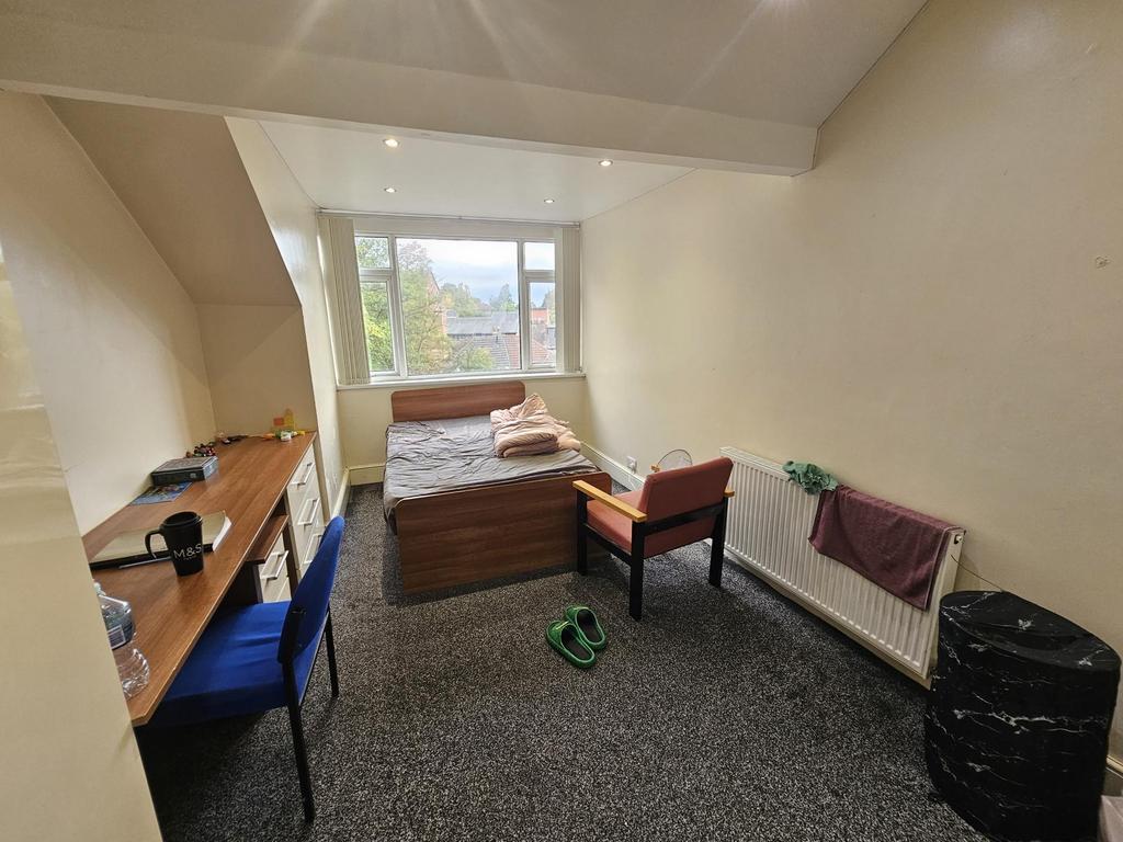 A cozy bedroom featuring a double bed against t...
