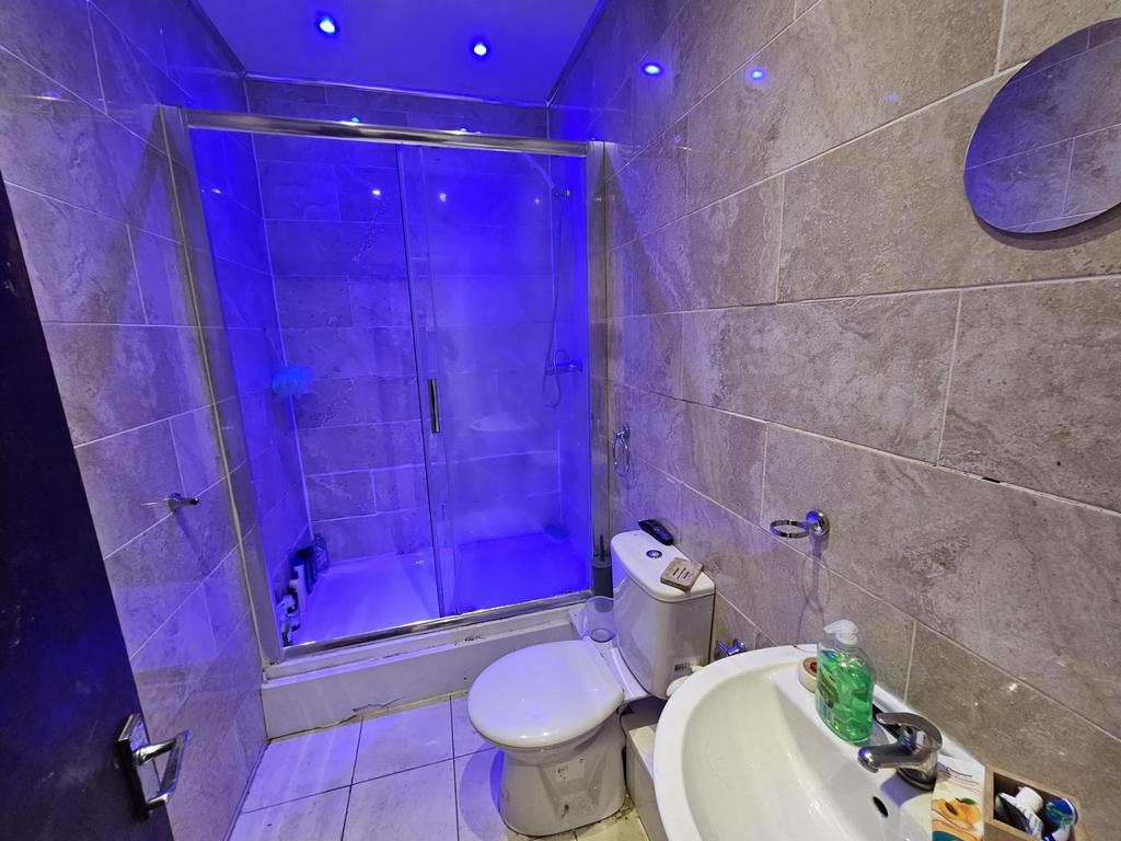 A modern bathroom featuring a large shower with...