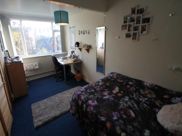 A cozy bedroom featuring a large bed with flora...