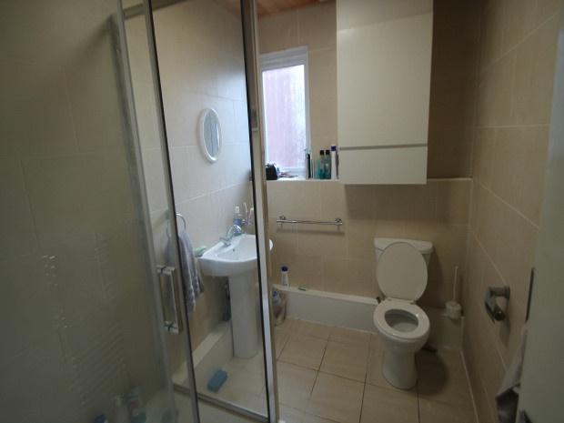 A modern bathroom with a toilet, sink, and show...