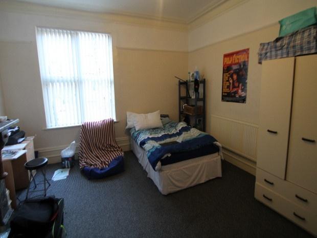 A cozy bedroom featuring a single bed, a wardro...