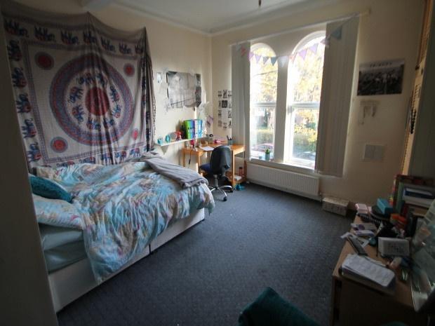 A spacious double bedroom with a large bed, amp...