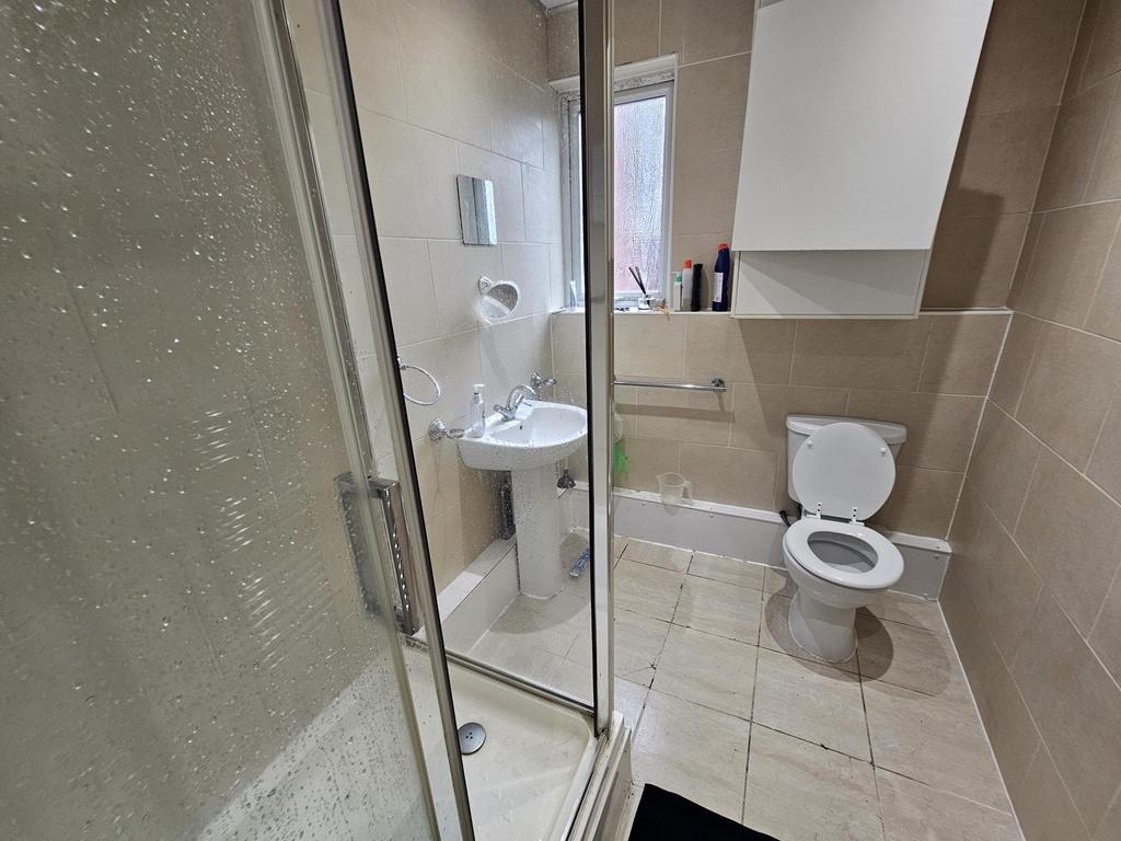 A clean, modern bathroom with a shower cabin an...