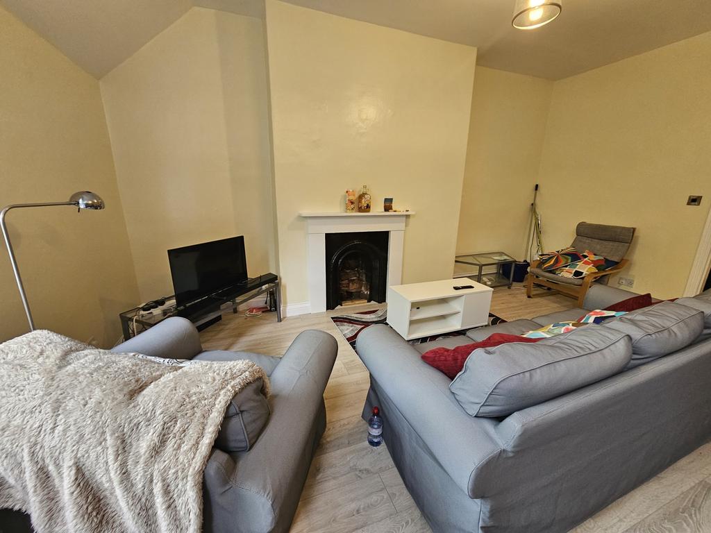 A spacious, well-lit living room featuring comf...
