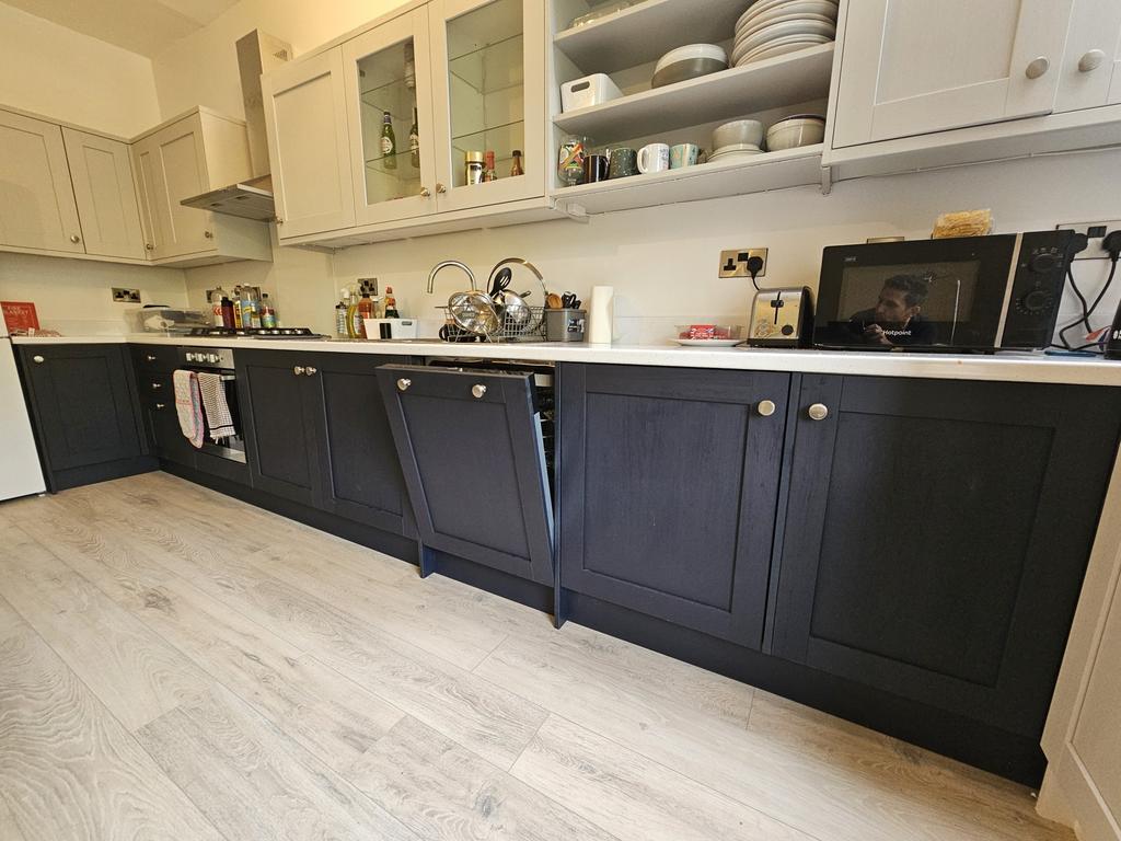 A modern kitchen with white upper cabinets and ...