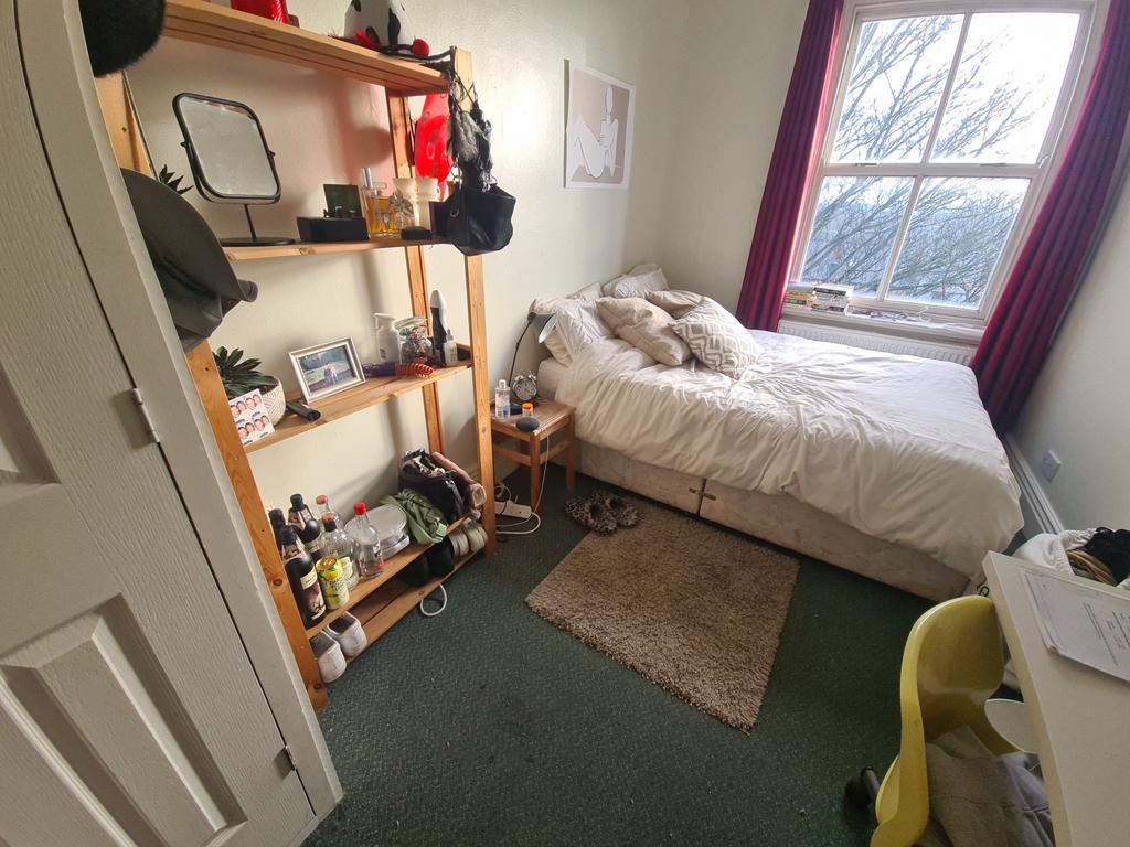 A cozy bedroom featuring a double bed near a wi...