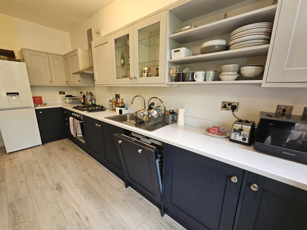 Modern kitchen with a sleek white countertop, a...