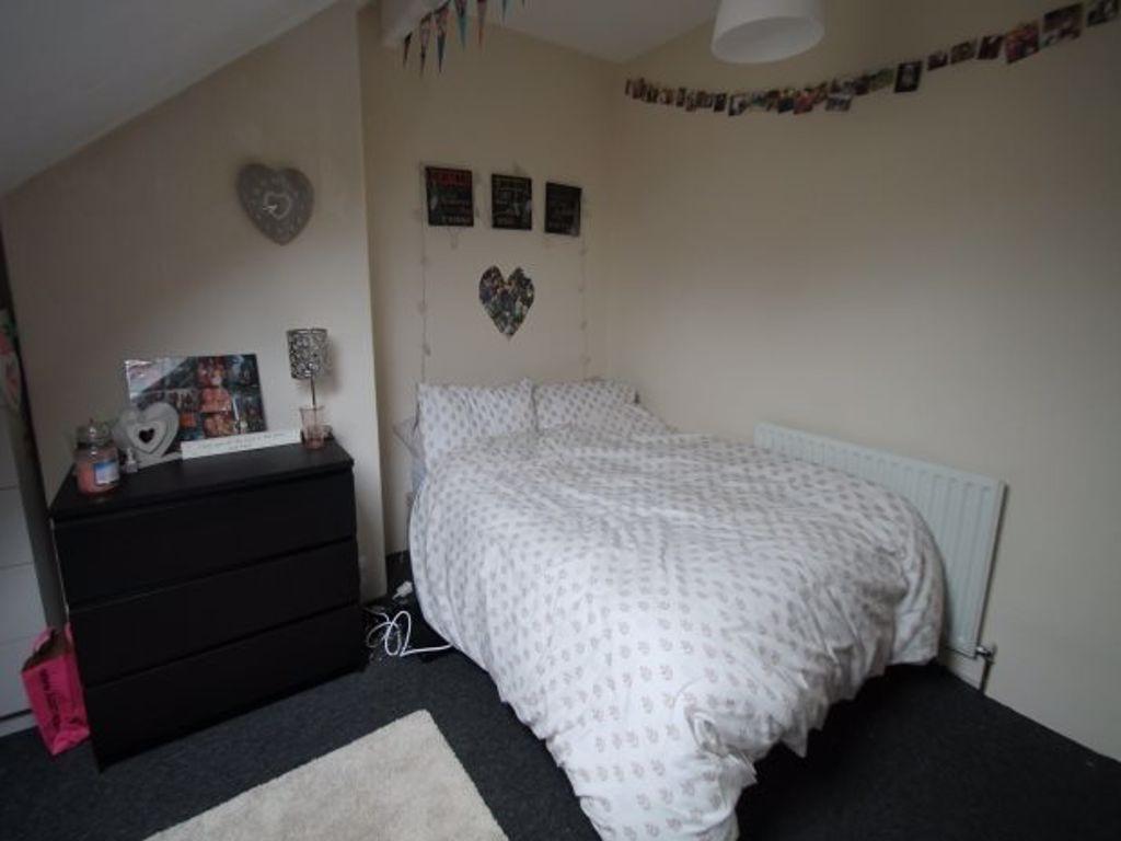 A cozy and tidy bedroom featuring a neatly made...