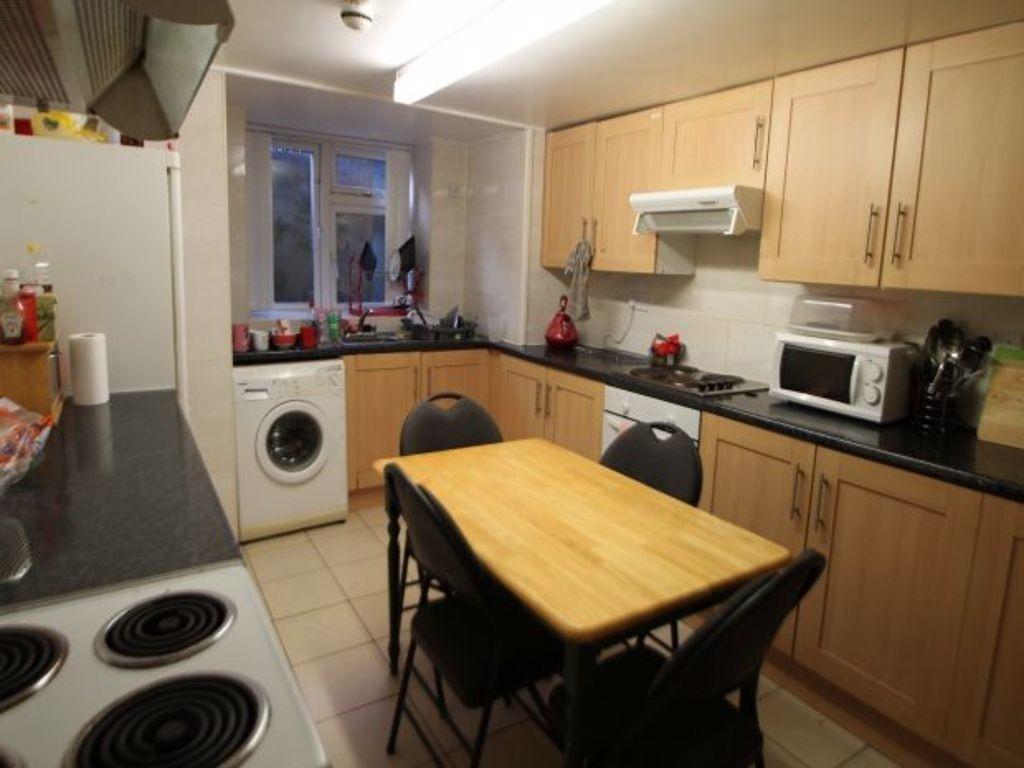 A well-lit kitchen with wooden cabinets and a s...