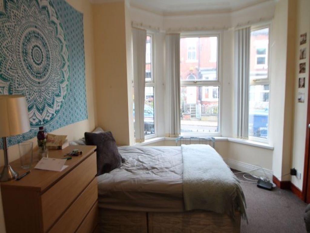 A spacious and well-lit master bedroom featurin...