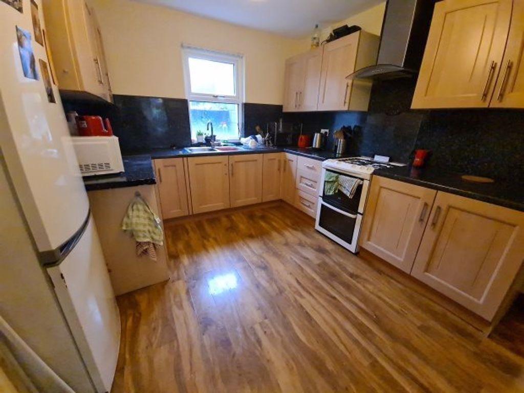 A well-lit kitchen with wooden cabinets, modern...