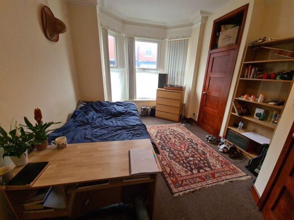 A cozy bedroom with a large window providing na...