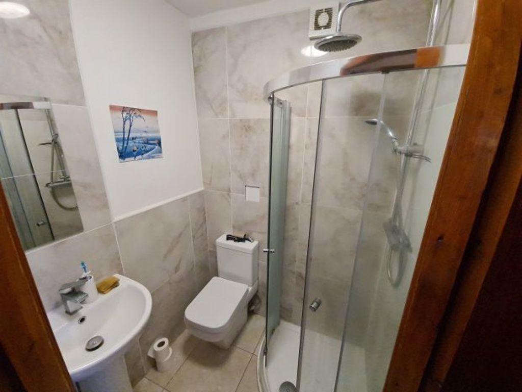 A modern bathroom featuring a glass-enclosed sh...