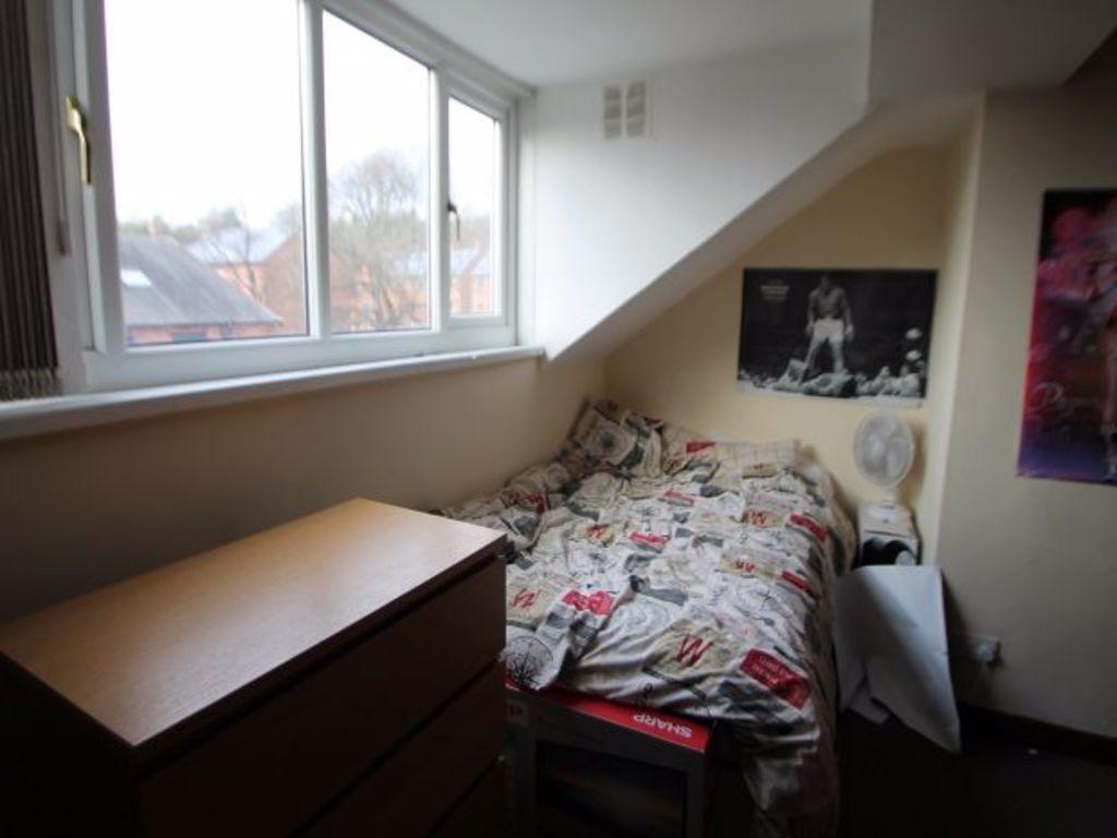 A cozy single bedroom featuring a neatly made b...